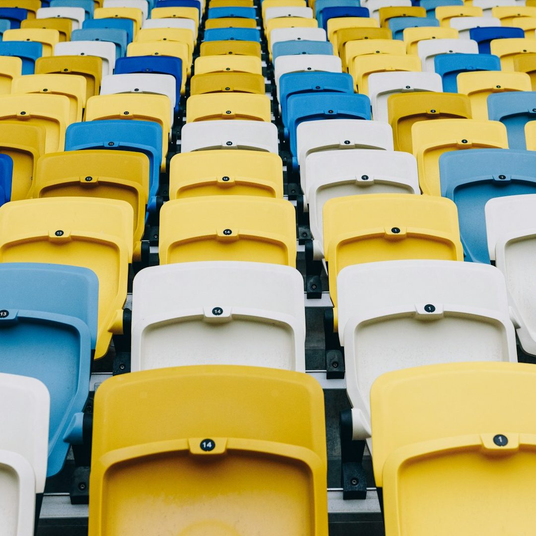 Organización de evento deportivo Asientos de un estadio en filas alternas de azul, blanco y amarillo.